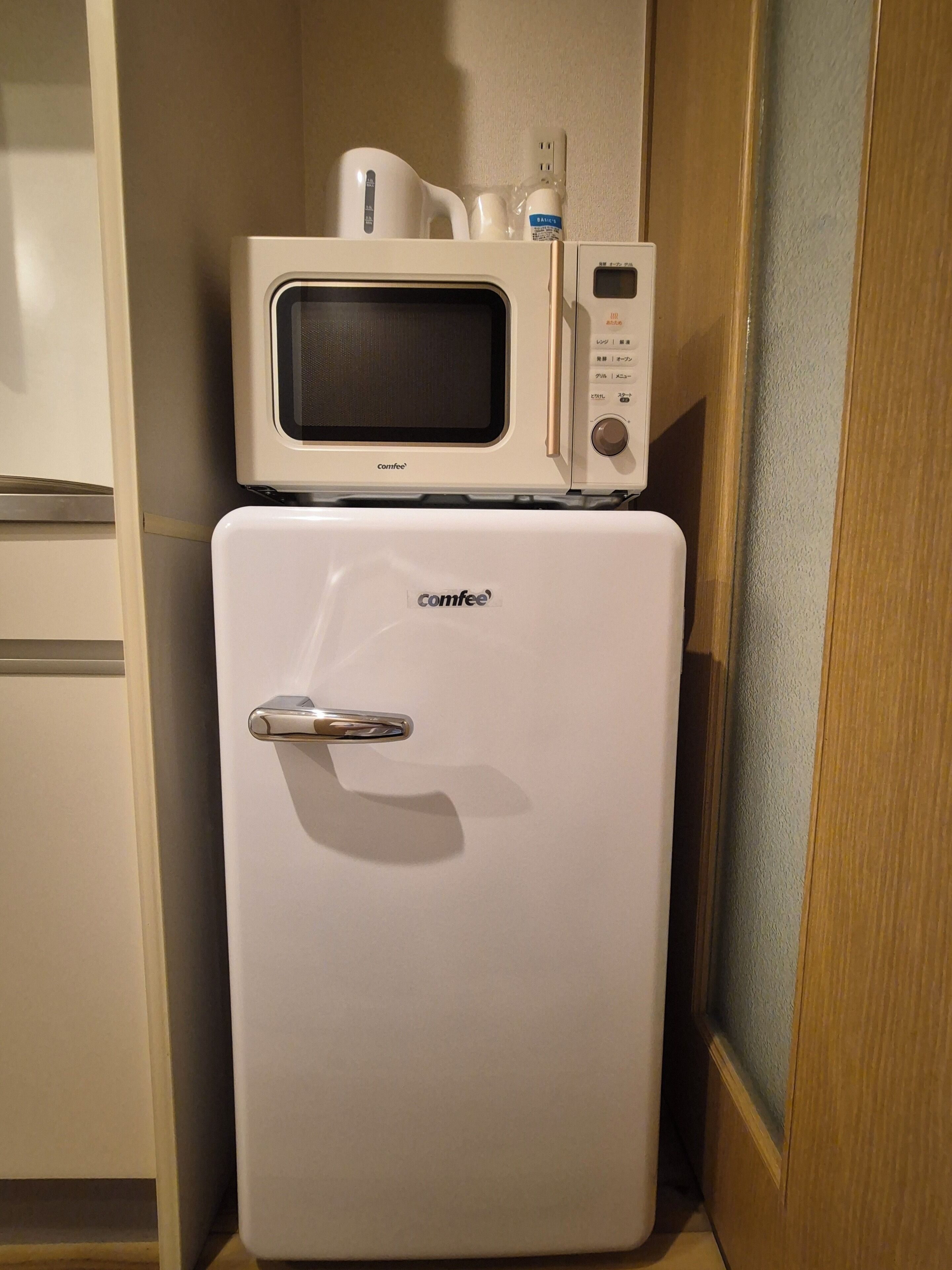 Un minibar blanco y compacto con un microondas y un refrigerador, ambos de la marca Comfee.