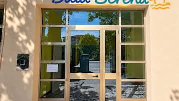 A building entrance with a sign reading 'Baia Serena' and a sun symbol.