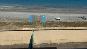 A beach view with a clear sky, a sandy shore, and a fence with a gate. - Baia Serena (Bellaria-Igea Marina)