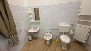 A small bathroom with a toilet, bidet, sink, and a mirror. - Baia Serena (Bellaria-Igea Marina)