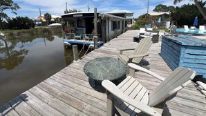 Un quai avec une péniche, des chaises longues et un jacuzzi.
