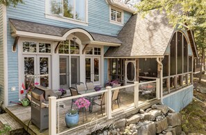 A house with a covered porch, outdoor seating, and a grill. - 6 bed 5 bath cottage on Lake Rosseau (Nipissing South (Utterson))