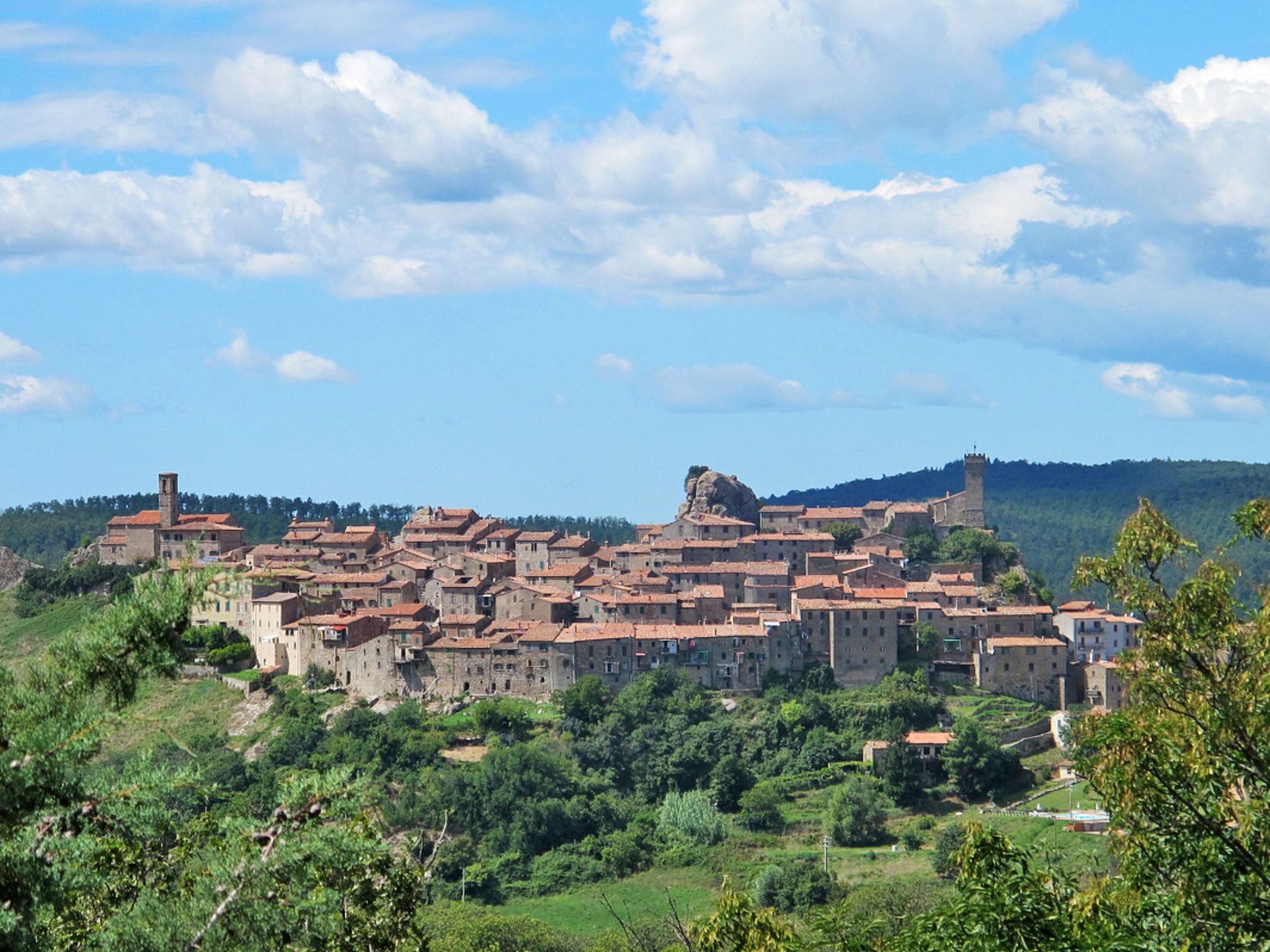 A historic town with medieval architecture, terraced fields, and a prominent castle.