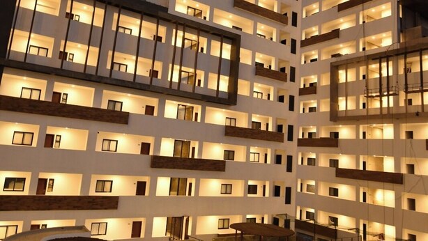 A multi-story hotel with a rooftop pool area, outdoor seating, and a well-lit facade. - Bonito departamento con vista al mar  (Mazatlán)
