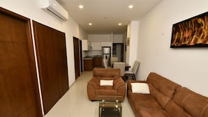 A modern living room with a sofa, a coffee table, and a dining area in the background. - Bonito departamento con vista al mar  (Mazatlán)