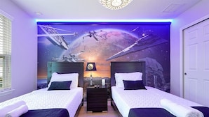 Een slaapkamer met twee bedden, een muurschildering met een ruimtethema en een plafondlamp.