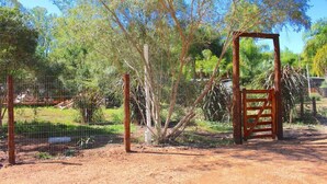 A fenced outdoor area with a wooden gate, trees, and a dirt ground. - 800 m Beach / Pet-friendly / Glamping (Sauce de Portezuelo)