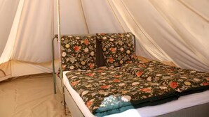 A tent with a bed inside, featuring a floral bedspread and pillows. - 800 m Beach / Pet-friendly / Glamping (Sauce de Portezuelo)