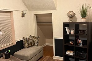 A cozy room with a grey sofa, a bookshelf, a globe, and a potted plant. - Cozy Updated 2BR Home Near Carondelet Park (St. Louis)