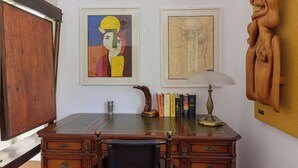 A wooden desk with a chair, books, a lamp, and two framed artworks on the wall. - La Sorgente by Interhome (Saturnia)
