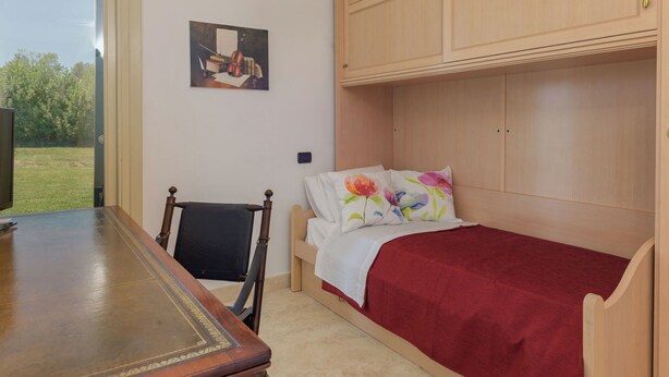 A room with a wooden bed, a desk, a chair, a painting on the wall, and a window. - La Sorgente by Interhome (Saturnia)