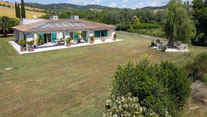 A house with a tiled roof, a covered patio, and a lawn. - La Sorgente by Interhome (Saturnia)
