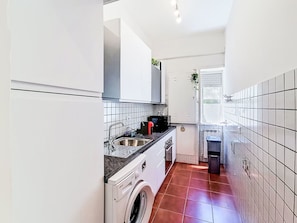 A compact kitchen with a washing machine, a sink, and a window. - Bemi' al mare by Interhome (Terracina)