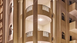 A hotel entrance with a grand staircase, columns, and a sign reading 'PALMERAS.'