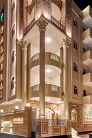 A hotel entrance with a grand staircase, columns, and a sign reading 'PALMERAS.'
