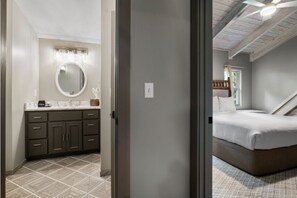 Ein Schlafzimmer mit einem Bett, einem Deckenventilator und Blick aus einem Fenster.