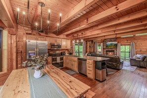 A spacious log cabin interior with a kitchen, dining area, and living room. - Dreamy Secluded Cabin Near Dollywood and GSMNP (Sevierville)