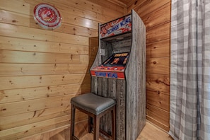 A wooden-paneled room with a vintage arcade machine labeled 'Donkey Kong' and a Coca-Cola branded clock. - Dreamy Secluded Cabin Near Dollywood and GSMNP (Sevierville)