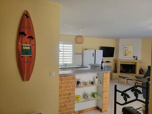 Eine kleine Küche mit Surfbret-Dekoration, einem Fernseher und einem Kamin.