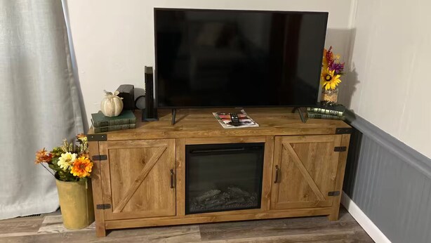A wooden entertainment center with a television, a magazine, and decorative items. - Caddy Corner has a hot tub just outside of town (French Lick)