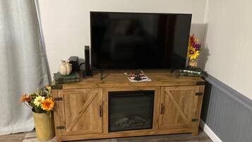 Un meuble de rangement en bois contenant une télévision, un magazine et des objets décoratifs.