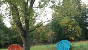 A fire pit with two Adirondack chairs, surrounded by gravel. - Caddy Corner has a hot tub just outside of town (French Lick)