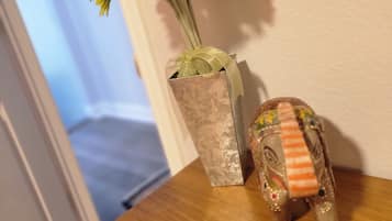 En vase med blomster og en dekorativ elefantfigur på en træoverflade.
