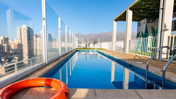A rooftop pool with clear views of a cityscape and mountains in the background. - San Isidro 635 (Santiago)