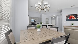 A modern dining room with a wooden table, chairs, and a chandelier. - Palomar: New Build, Hot Tub, Pet-Friendly, BBQ (Albuquerque)