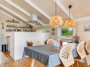 Ein Essbereich mit einem für vier Personen gedeckten Tisch, umgeben von stuhlartigen Sitzgelegenheiten mit einem besonderen Design.