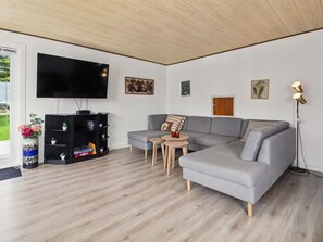 A modern living room with a grey sectional sofa, a flat-screen TV, a black entertainment unit, and a small round table with two chairs. - "Tessa" - 19km from the sea by Interhome (Højer)