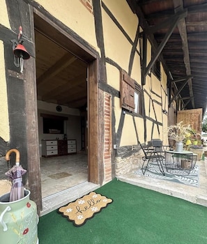 Un bâtiment traditionnel avec une porte en bois, une cloche et un paillasson.