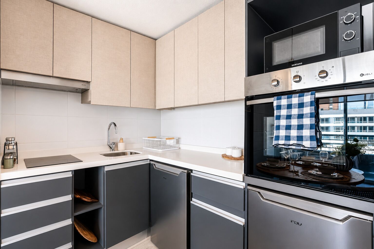 A modern kitchen with a dishwasher, oven, and microwave.