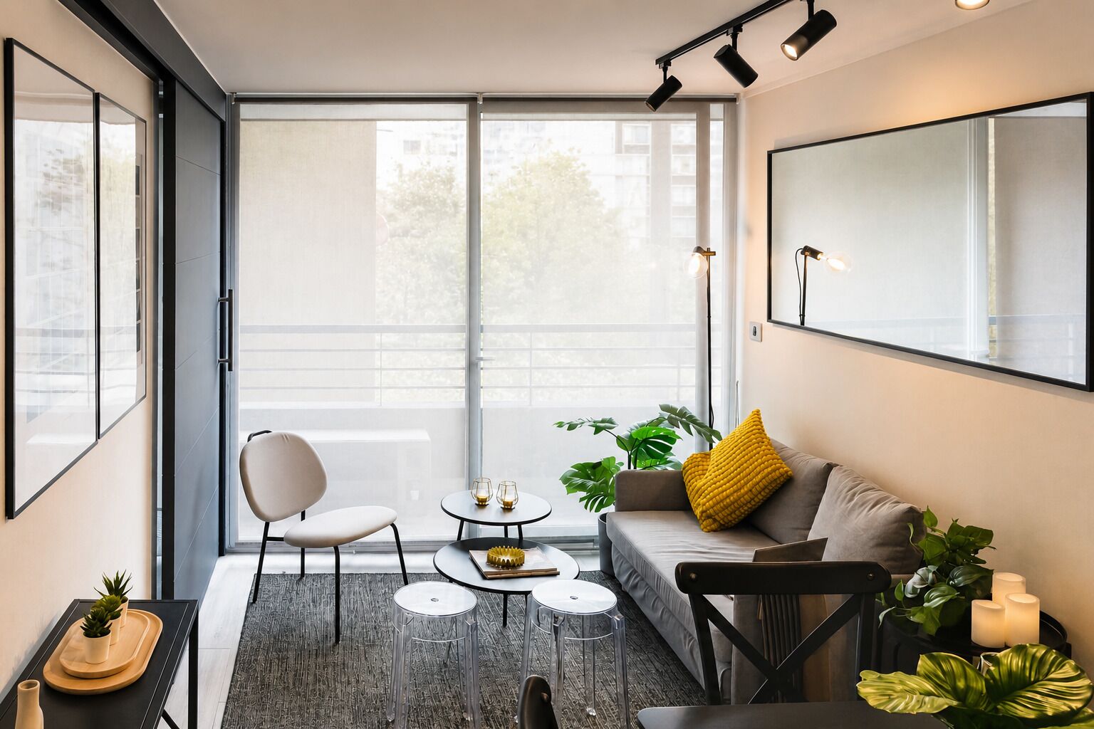 Una sala de estar moderna con sofá, sillas, una mesa de centro y un ventanal grande.
