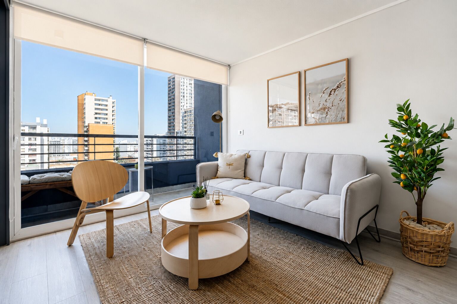 A modern living room with a sofa, a round coffee table, a chair, a small table with a plant, and a large window with a view of buildings.