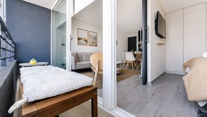 Un dormitorio moderno con una cama, una mesita y un televisor.