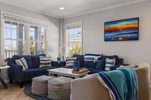 A living room with two sofas, a coffee table, and a painting on the wall. - Steps to beach | Ocean Views | Beach Gear (Carolina Beach)