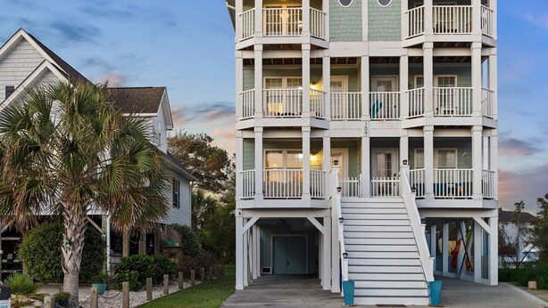 Un edificio de varios pisos con balcones, una escalera y una entrada principal.