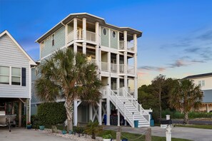 A multi-story building with balconies, a staircase, and a boat in the driveway. - Steps to beach | Ocean Views | Beach Gear (Carolina Beach)
