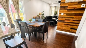 Eine moderne Küche mit Holzboden, einer Essecke mit Tisch und Stühlen sowie einem Deckenventilator.