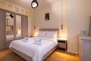 A hotel room with a bed, bedside tables, a wardrobe, and a painting on the wall. - Tbilisi Legend – Rustaveli 37 (T'bilisi)