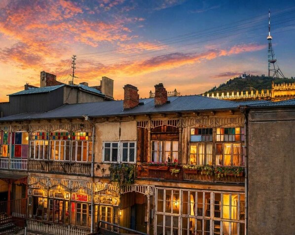 A multi-story building with balconies and a tower in the background. - Tbilisi Legend – Rustaveli 37 (T'bilisi)