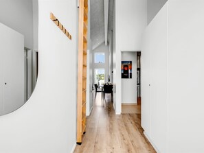 A modern interior with a wooden staircase, a dining area, and a kitchen. - "Halldora" - 300m from the sea by Interhome (Ringkøbing)