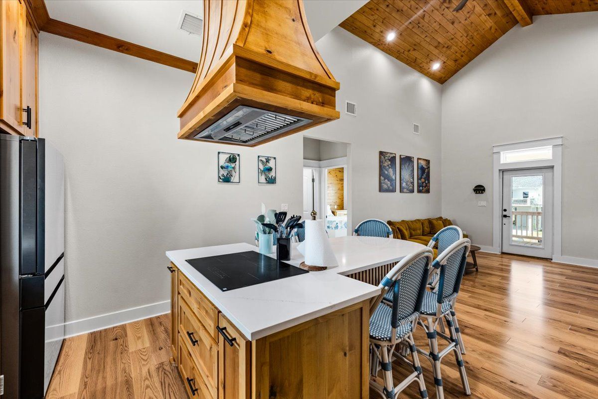 A kitchen with a central island, wooden cabinets, and a ceiling fan.