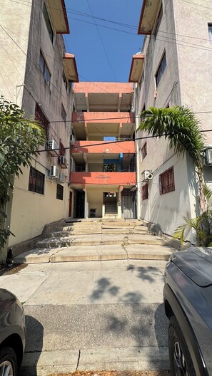A multi-story building with a central staircase leading to an entrance.