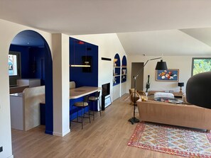 Ein modernes Interieur mit Essbereich, Sitzgelegenheiten und einem großen Fenster.
