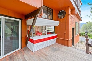 Ein Holzhaus mit überdachter Terrasse, einer Treppe und einer Tür.