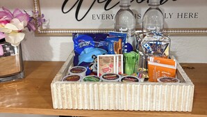 A welcome sign, a tray with snacks, a water bottle, and a coffee maker on a kitchen counter. - 3-bedroom apartment in peaceful Stuart with cool AC (Stuart)