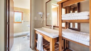 A bathroom with a wooden vanity, a mirror, a towel rack, and a shower area. - Family bungalow : Garden and barbecue : Playa Bonita Bariloche (San Carlos de Bariloche)