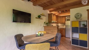 A kitchen with wooden cabinets, a built-in oven, and a wall-mounted TV. - Le Petit Riondet - SAINT NICOLAS LA CHAPELLE (SAINT NICOLAS LA CHAPELLE)